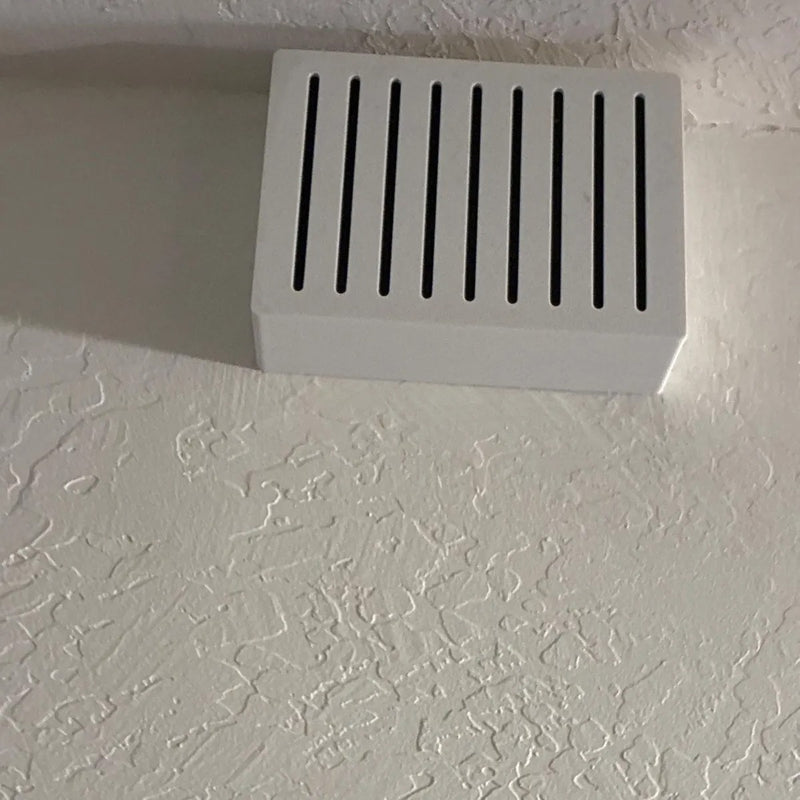 White Louver chime cover on a textured wall, angled view