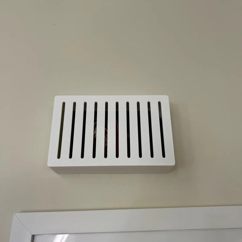 White Louver chime cover on a wall above a white picture frame
