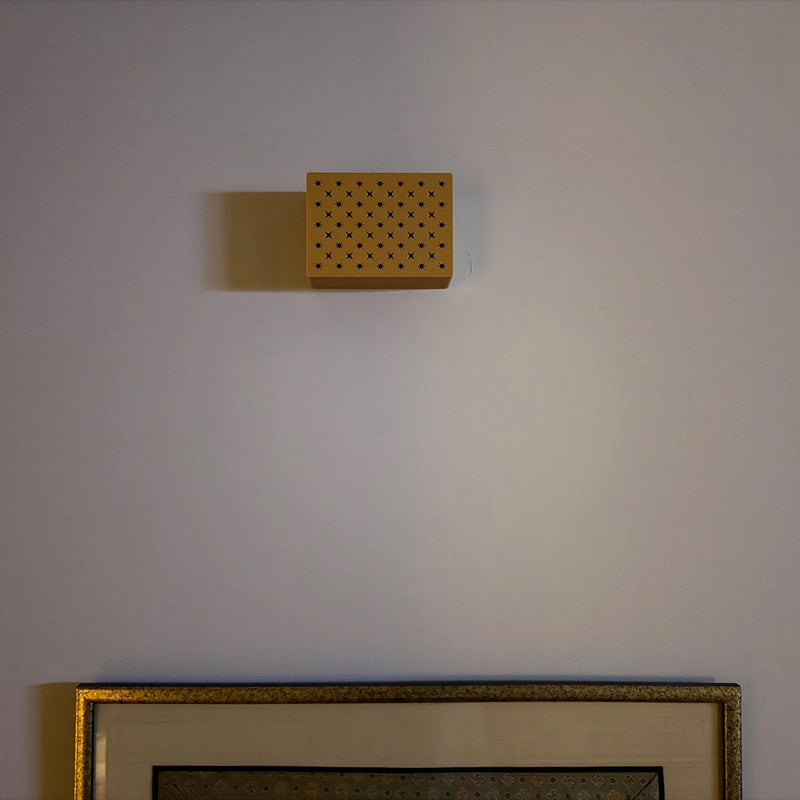 Gold Flowers chime cover on a wall above a framed picture